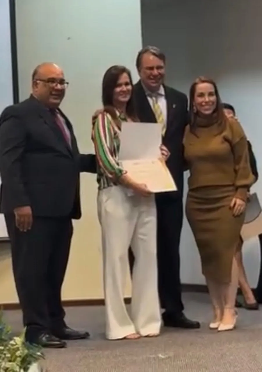 Dra. Simone Carrara com certificado, acompanhada de representantes em cerimônia do CRO-DF.