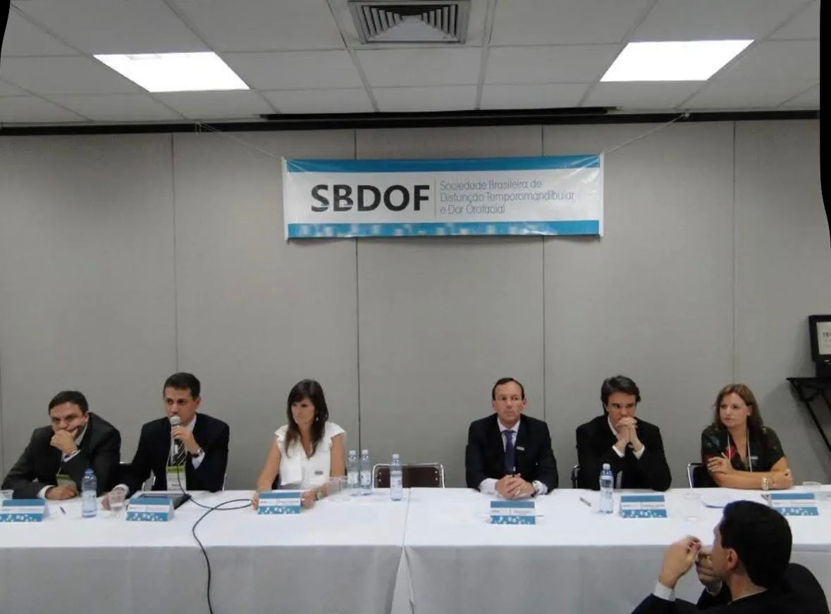 Mesa do evento de fundação da SBDOF, com participantes reunidos sob o painel da sociedade.